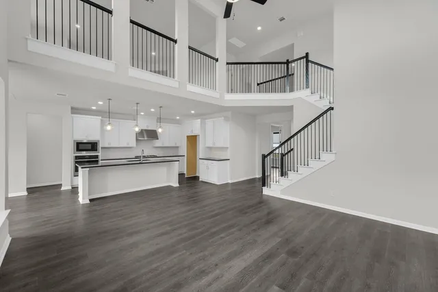 a large white kitchen with lots of counter space a sink and stainless steel appliances