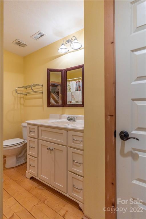1553 Zacks Fork Road Lenoir, NC 28645 - Photo 27 of 48 a bathroom with a toilet sink and mirror