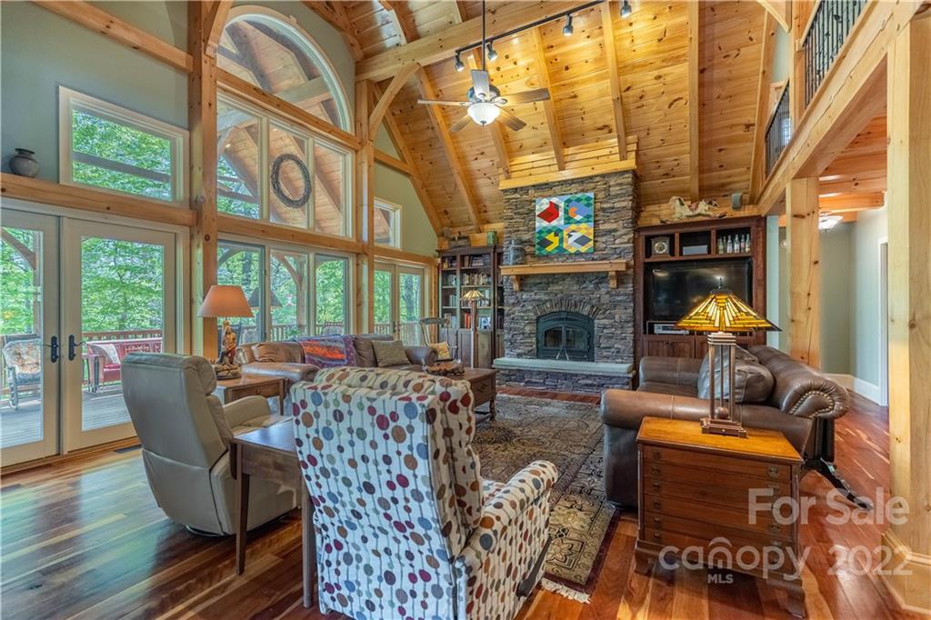 1553 Zacks Fork Road Lenoir, NC 28645 - Photo 5 of 48 a living room with furniture a fireplace and a floor to ceiling window