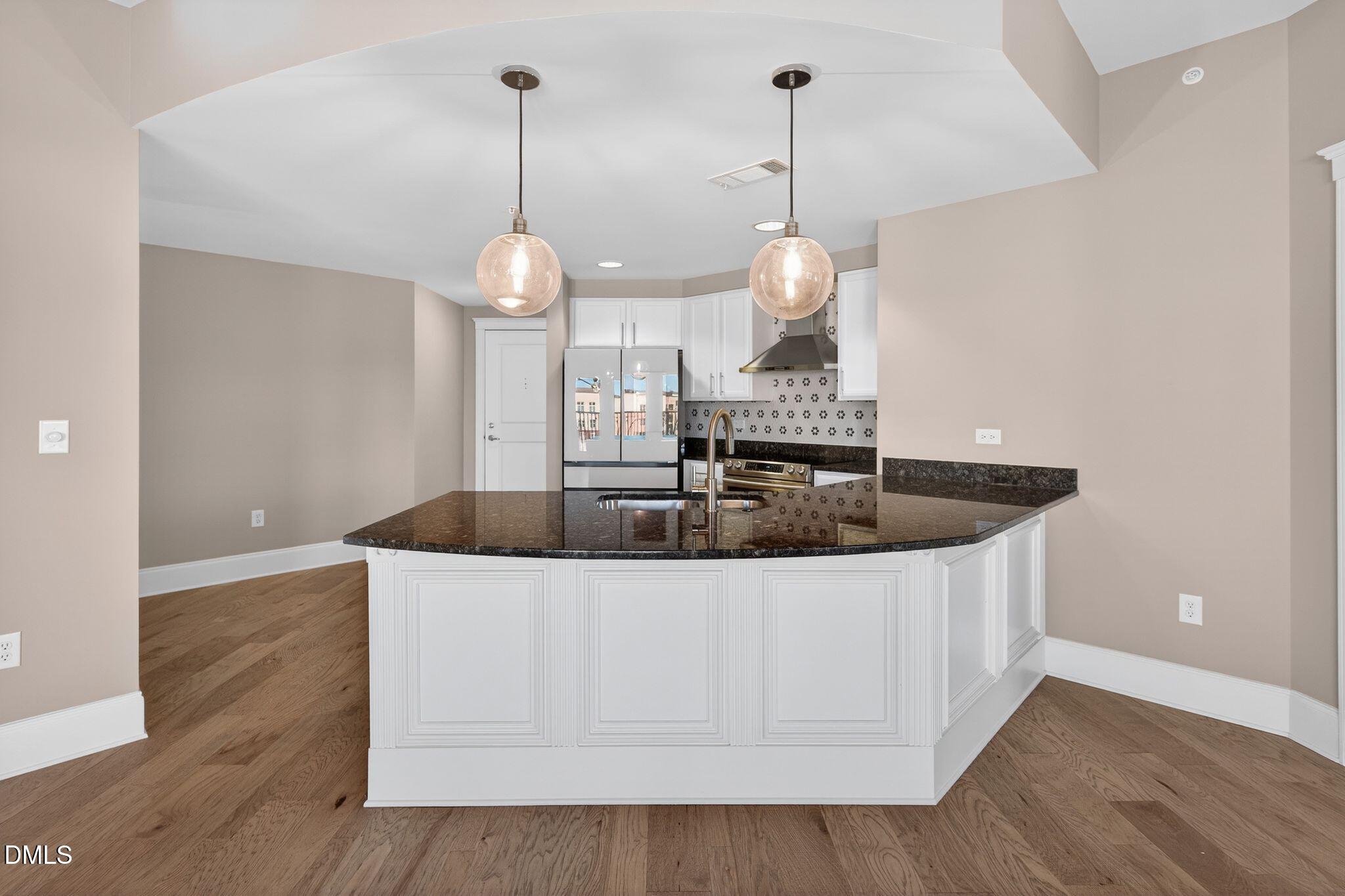 222 Glenwood Avenue, Unit 605 Raleigh, NC 27603 - Photo 10 of 60 a kitchen with a sink a counter space and wooden floor