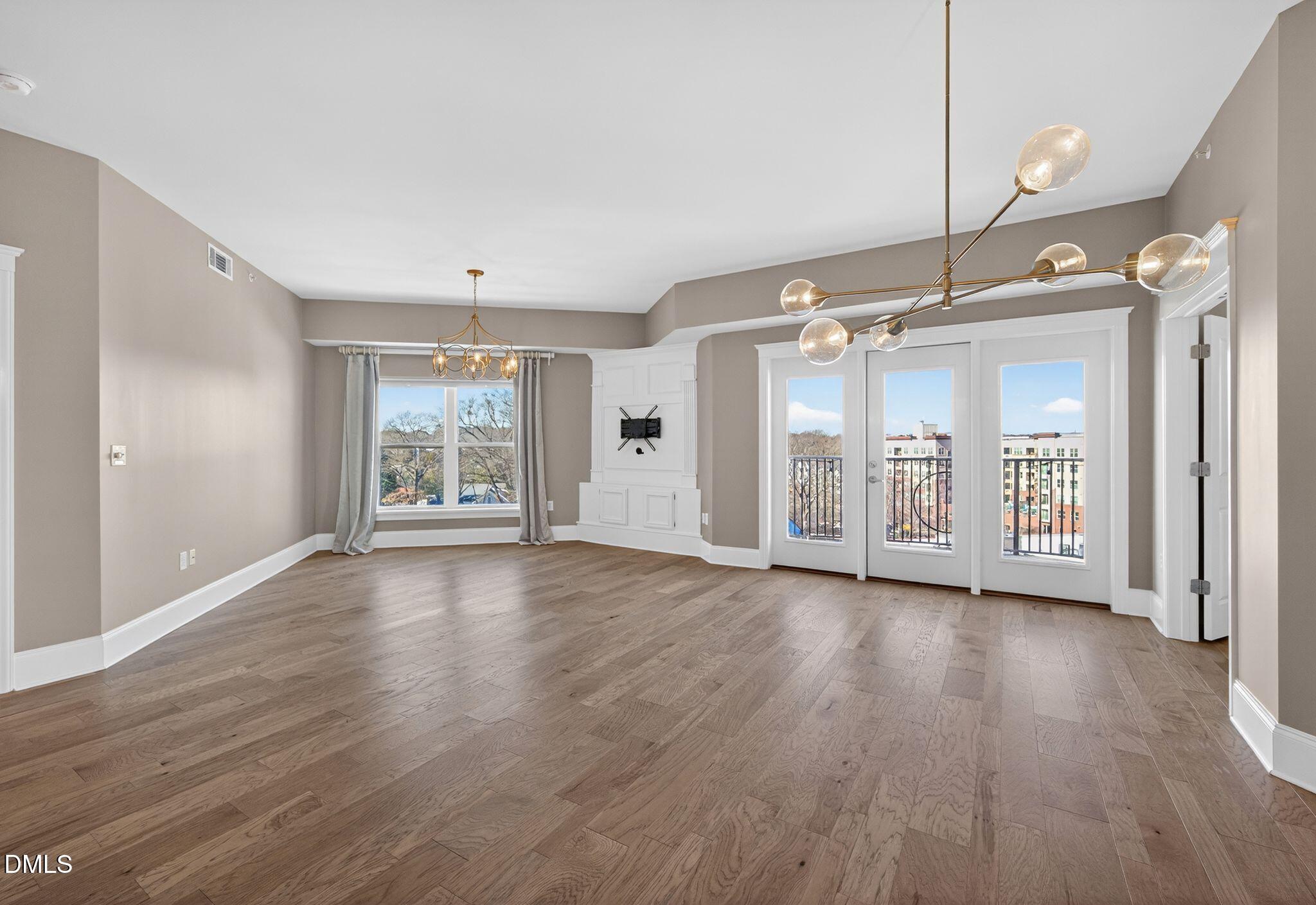 222 Glenwood Avenue, Unit 605 Raleigh, NC 27603 - Photo 13 of 60 a view of an empty room with wooden floor and a window