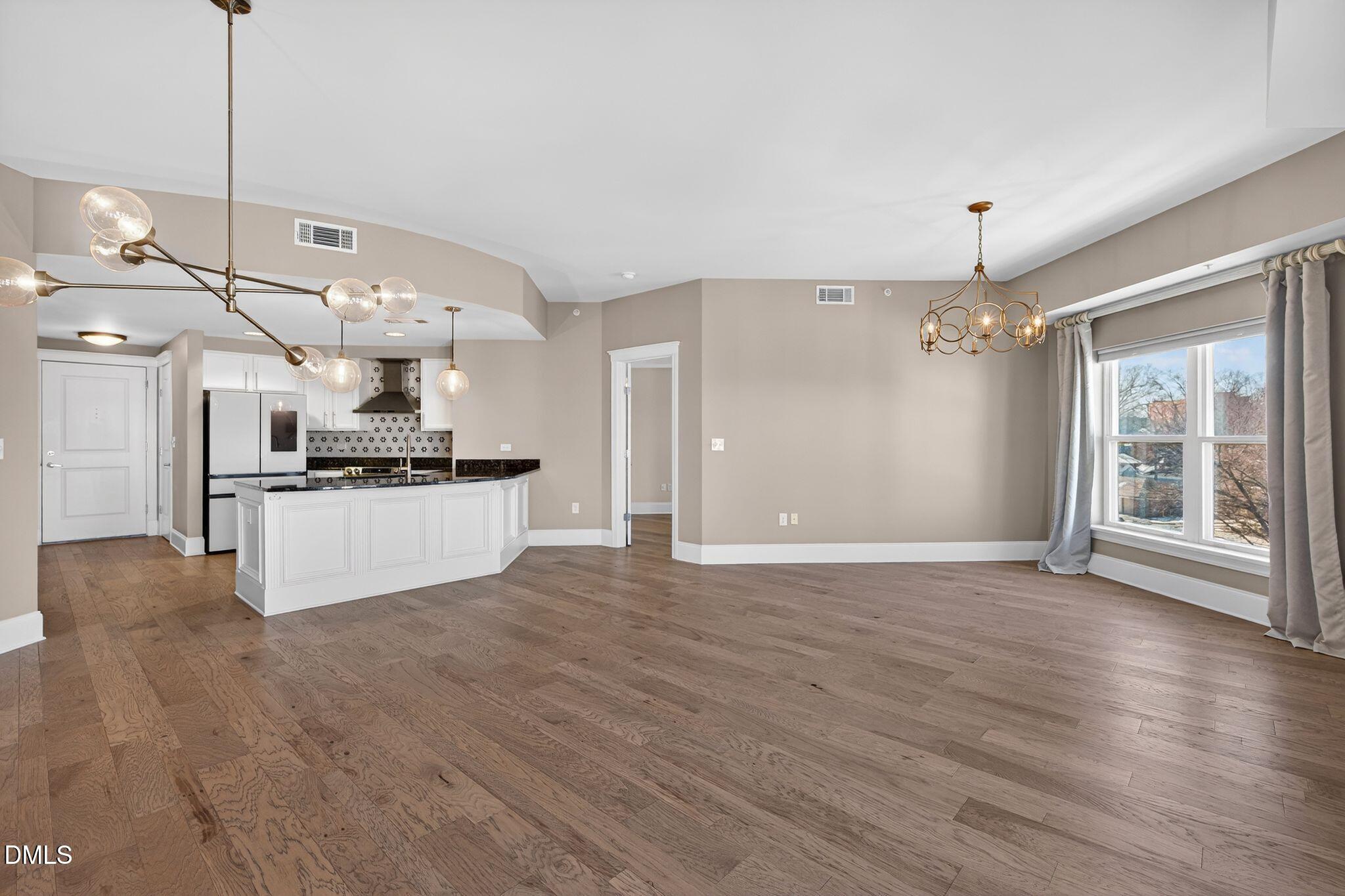 222 Glenwood Avenue, Unit 605 Raleigh, NC 27603 - Photo 17 of 60 a view of an empty room with kitchen and a window