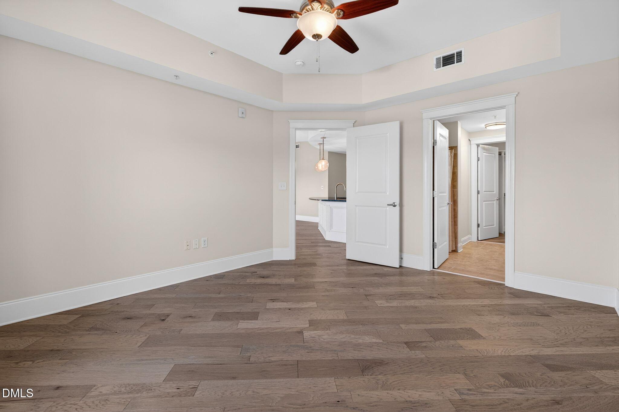 222 Glenwood Avenue, Unit 605 Raleigh, NC 27603 - Photo 23 of 60 a view of an empty room with a ceiling fan