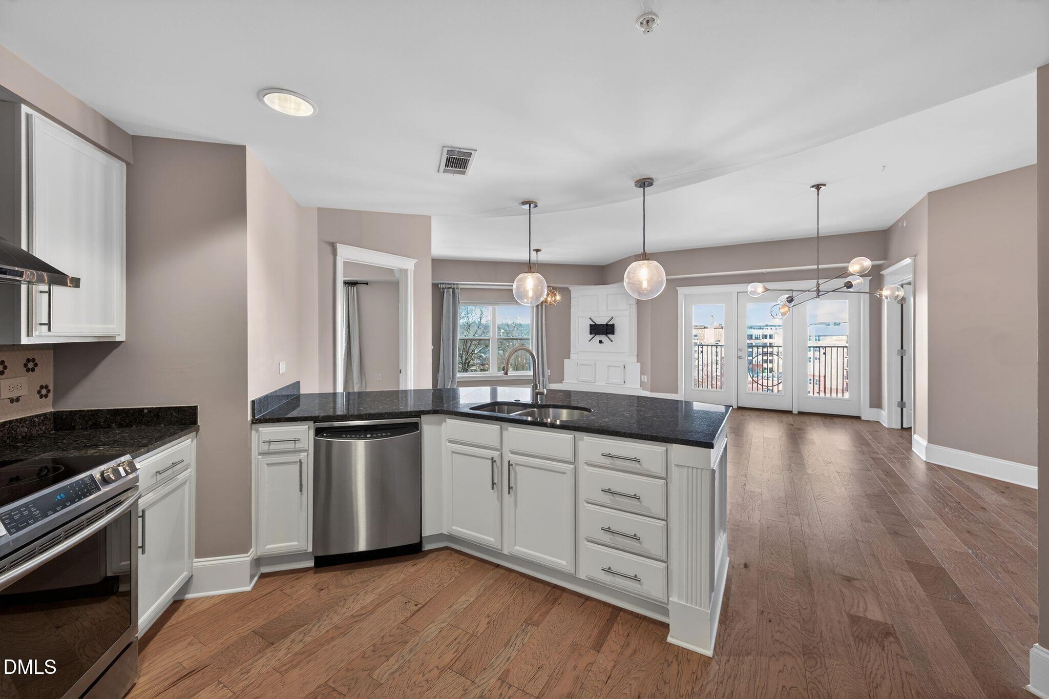 222 Glenwood Avenue, Unit 605 Raleigh, NC 27603 - Photo 6 of 60 a kitchen with granite countertop a sink cabinets and stainless steel appliances