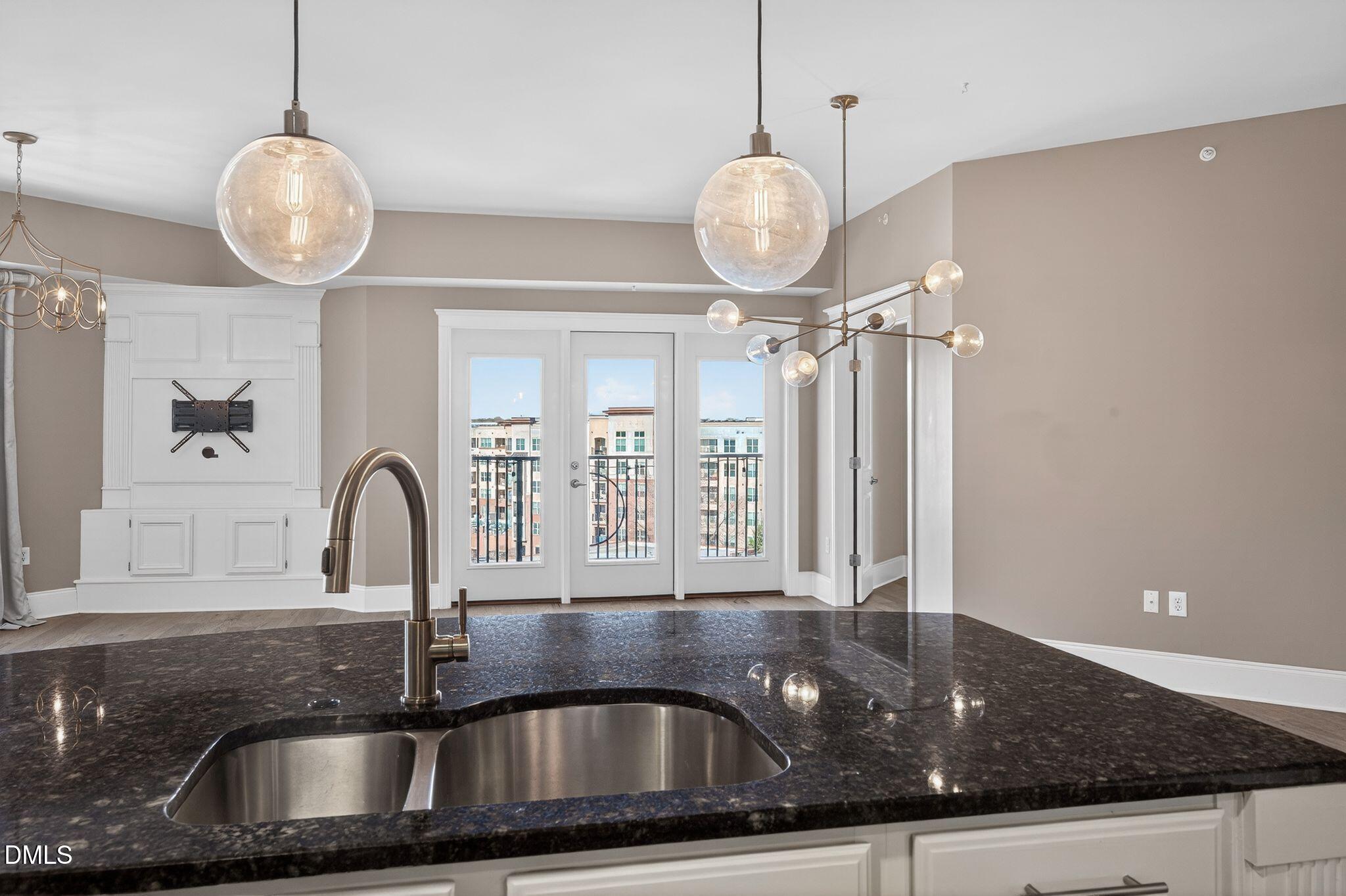 222 Glenwood Avenue, Unit 605 Raleigh, NC 27603 - Photo 8 of 60 a kitchen with a sink and chandelier