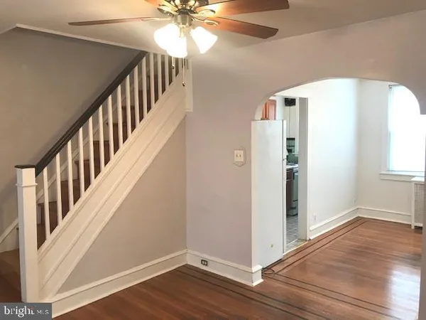a view of a hallway with wooden floor and staircase