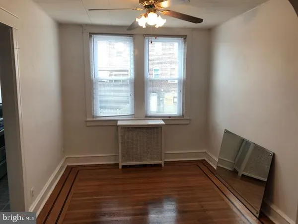 a room with wooden floor and windows