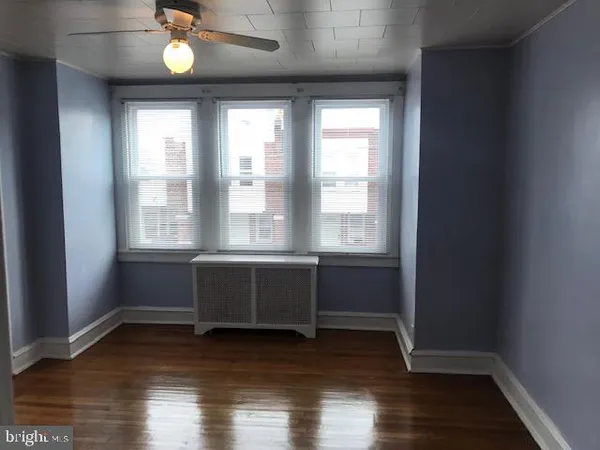 a room with wooden floor and windows