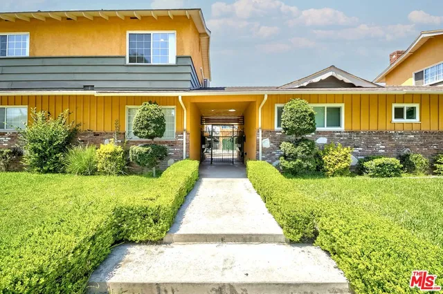 a front view of a house with a garden and plants