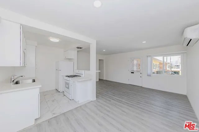 a view of a kitchen with white cabinets and wooden floor