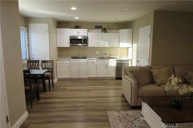 a kitchen with kitchen island granite countertop a stove top oven a sink and a refrigerator