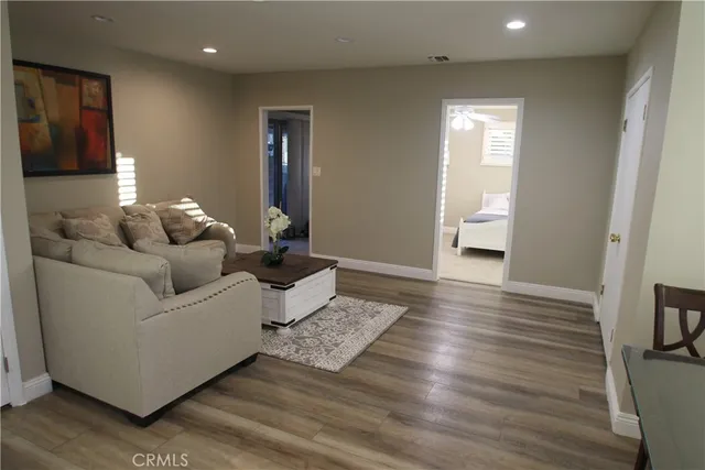 a living room with furniture and a wooden floor