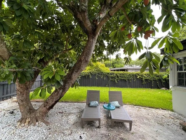 a front view of a house with garden and a yard