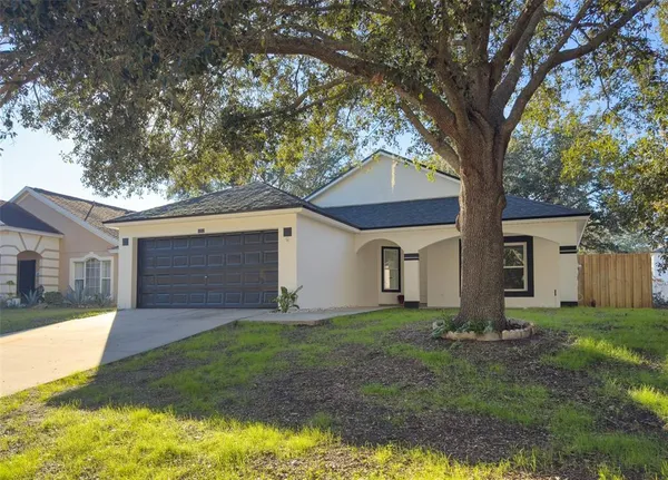 a front view of house with yard and trees