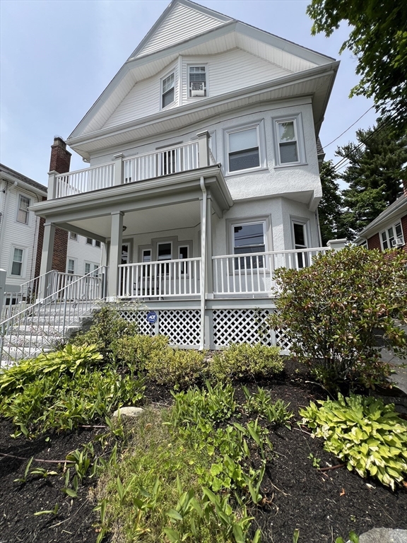 67 Commonwealth Road, Unit 2 Watertown, MA 02472 - Photo 1 of 12 a front view of a house with a garden