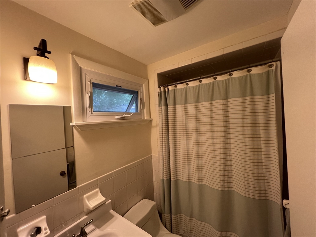 67 Commonwealth Road, Unit 2 Watertown, MA 02472 - Photo 11 of 12 a bathroom with a sink and a mirror