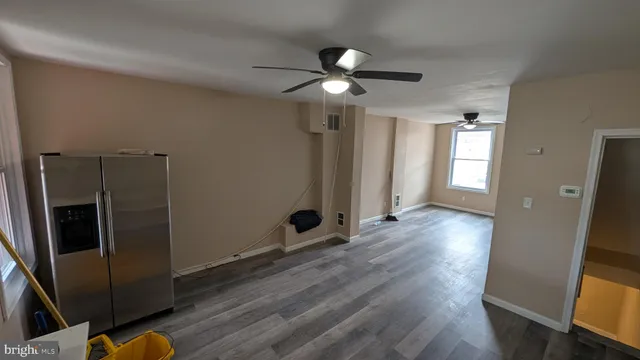 a view of a livingroom with wooden floor and a ceiling fan