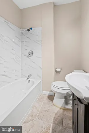 a bathroom with a toilet a sink and bathtub