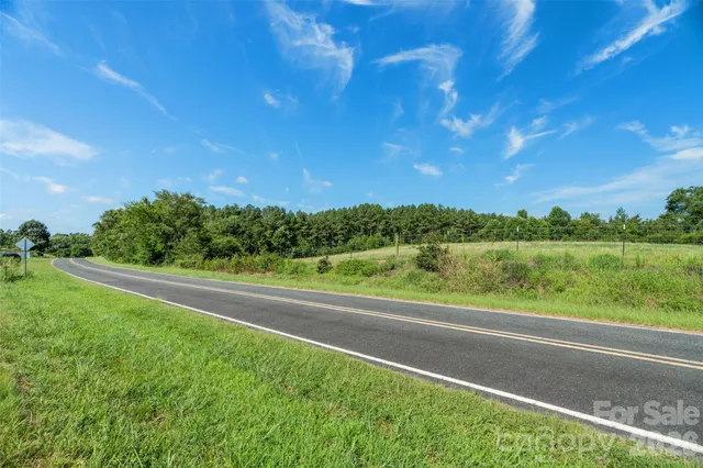a view of a green field with wooden fence