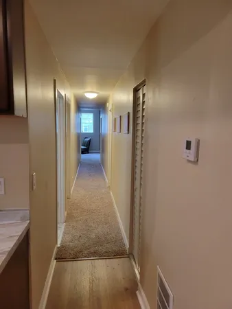 a view of a hallway with wooden floor