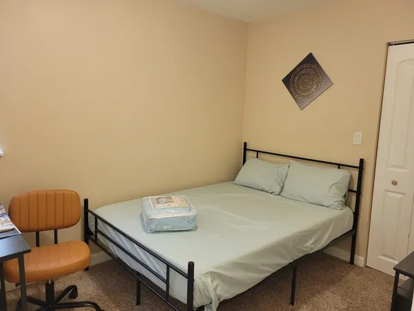 a bedroom with a bed and a chair