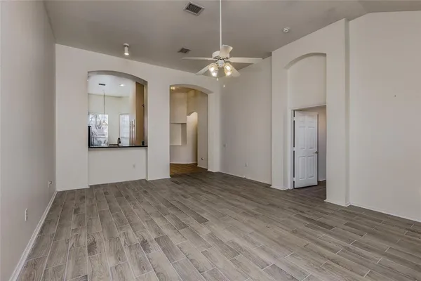 an empty room with wooden floor and mirror