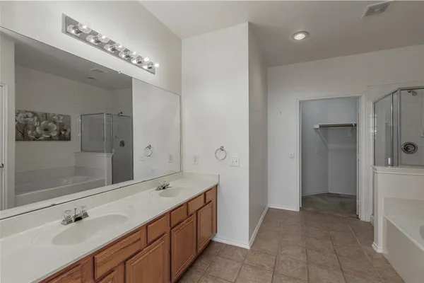 a spacious bathroom with a double vanity sink a mirror and shower