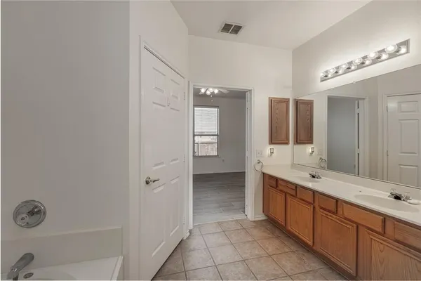 a spacious bathroom with a double vanity sink a mirror and a shower