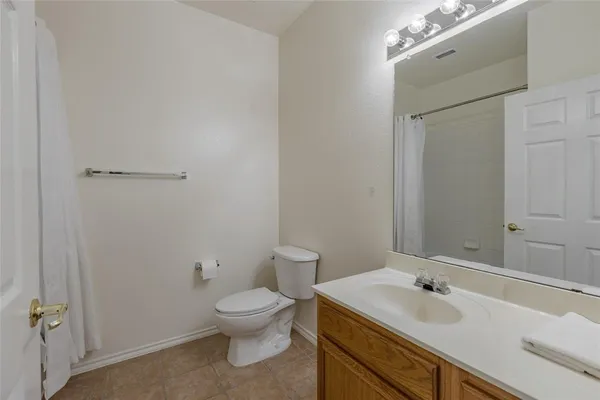 a bathroom with a toilet sink vanity and mirror