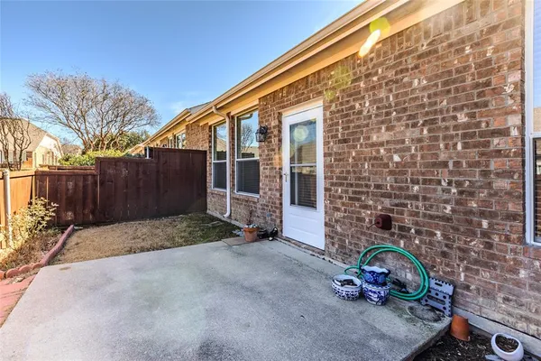 a backyard of a house with chairs and wooden fence