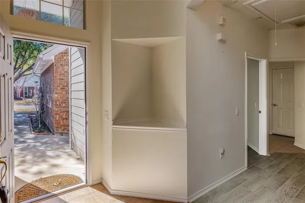 a view of a hallway with wooden floor and windows