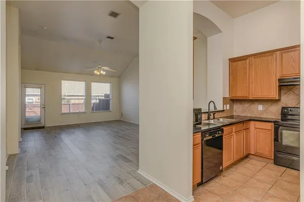 a kitchen with stainless steel appliances granite countertop a stove a sink and a refrigerator