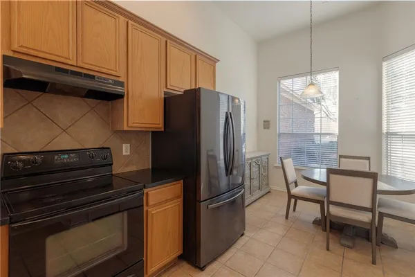 a kitchen with stainless steel appliances granite countertop a refrigerator stove and microwave