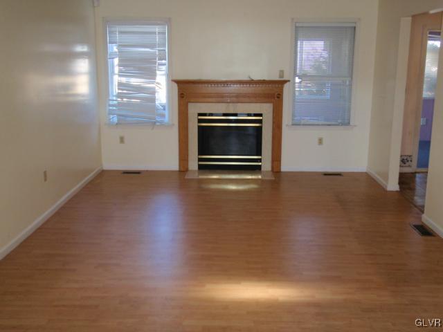 207 Stephanie Drive Easton, PA 18045 - Photo 2 of 15 an empty room with wooden floor fireplace and windows