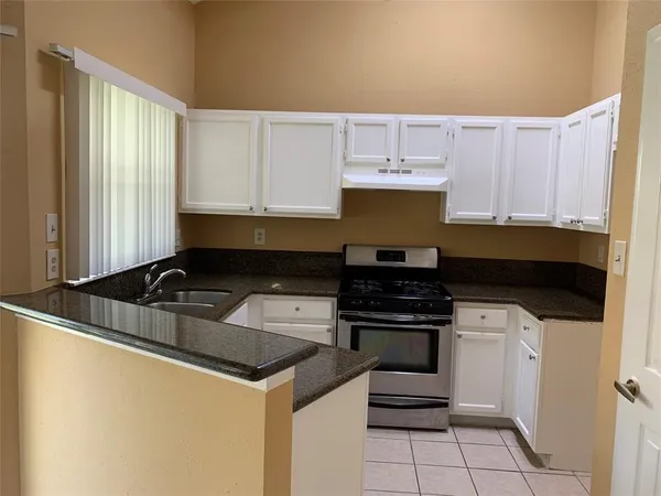 a kitchen with granite countertop a stove and a sink