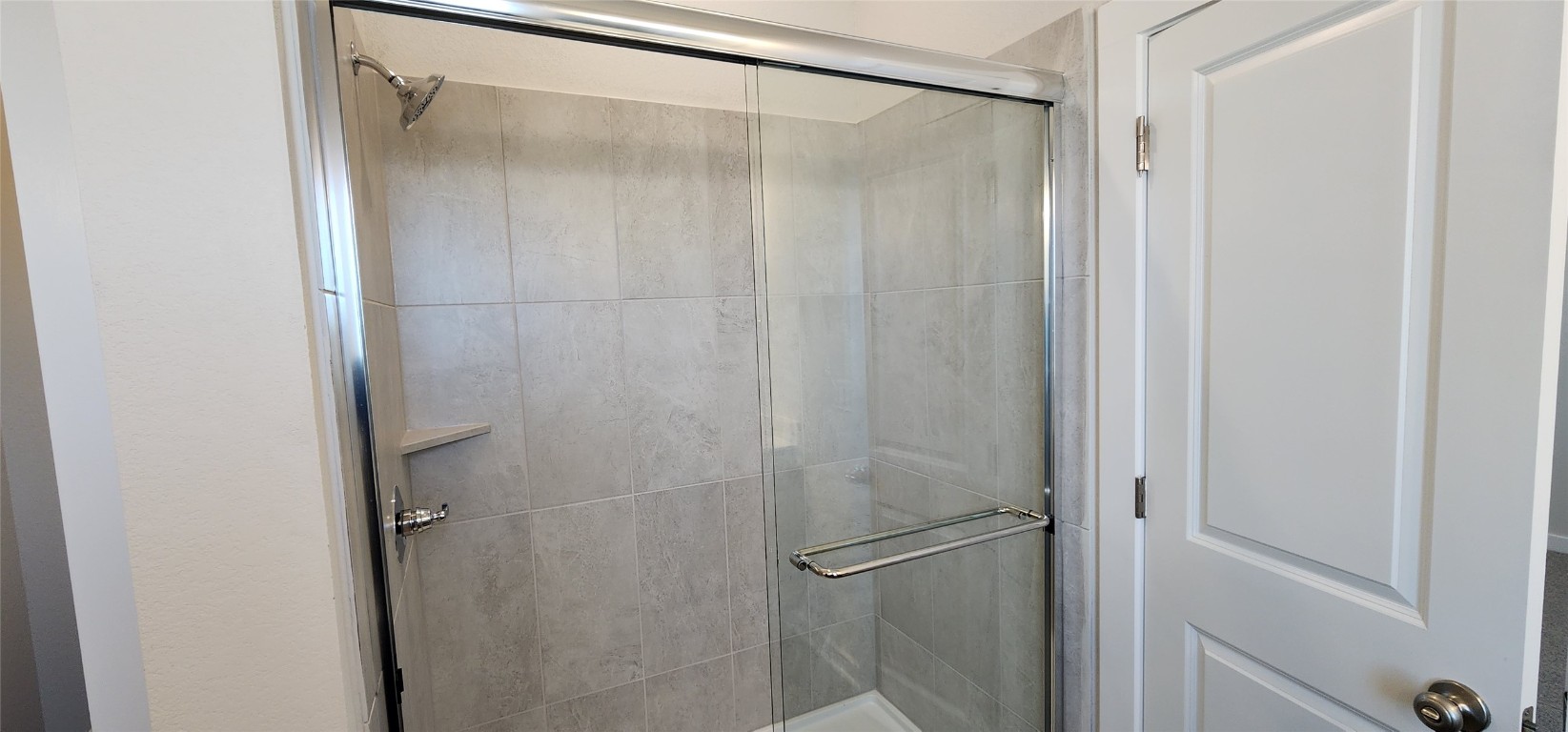 2232 Delano Drive Leander, TX 78641 - Photo 17 of 36 a bathroom with a glass shower door