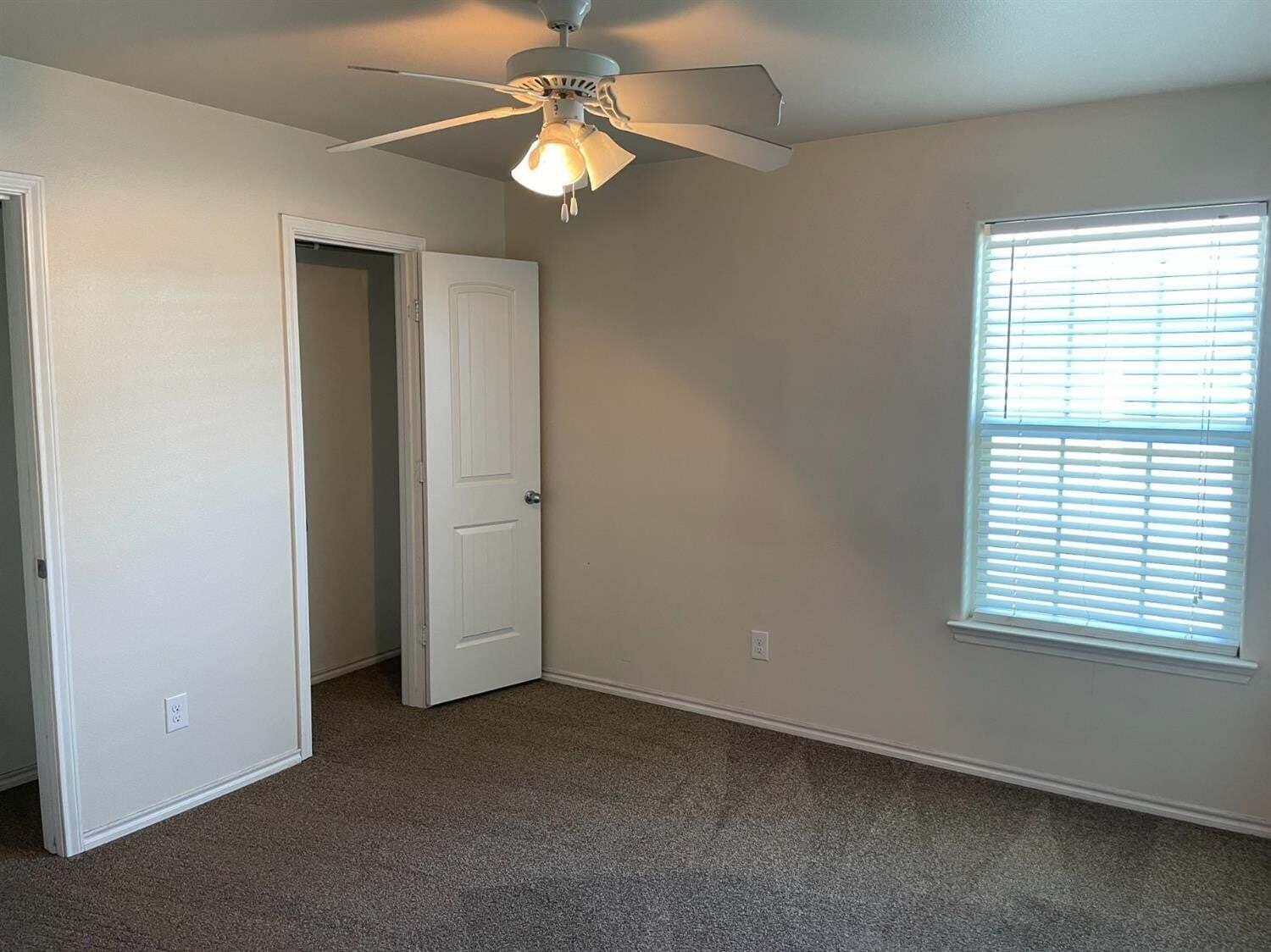 8912 Terrell Avenue Lubbock, TX 79423 - Photo 8 of 11 an empty room with windows and fan