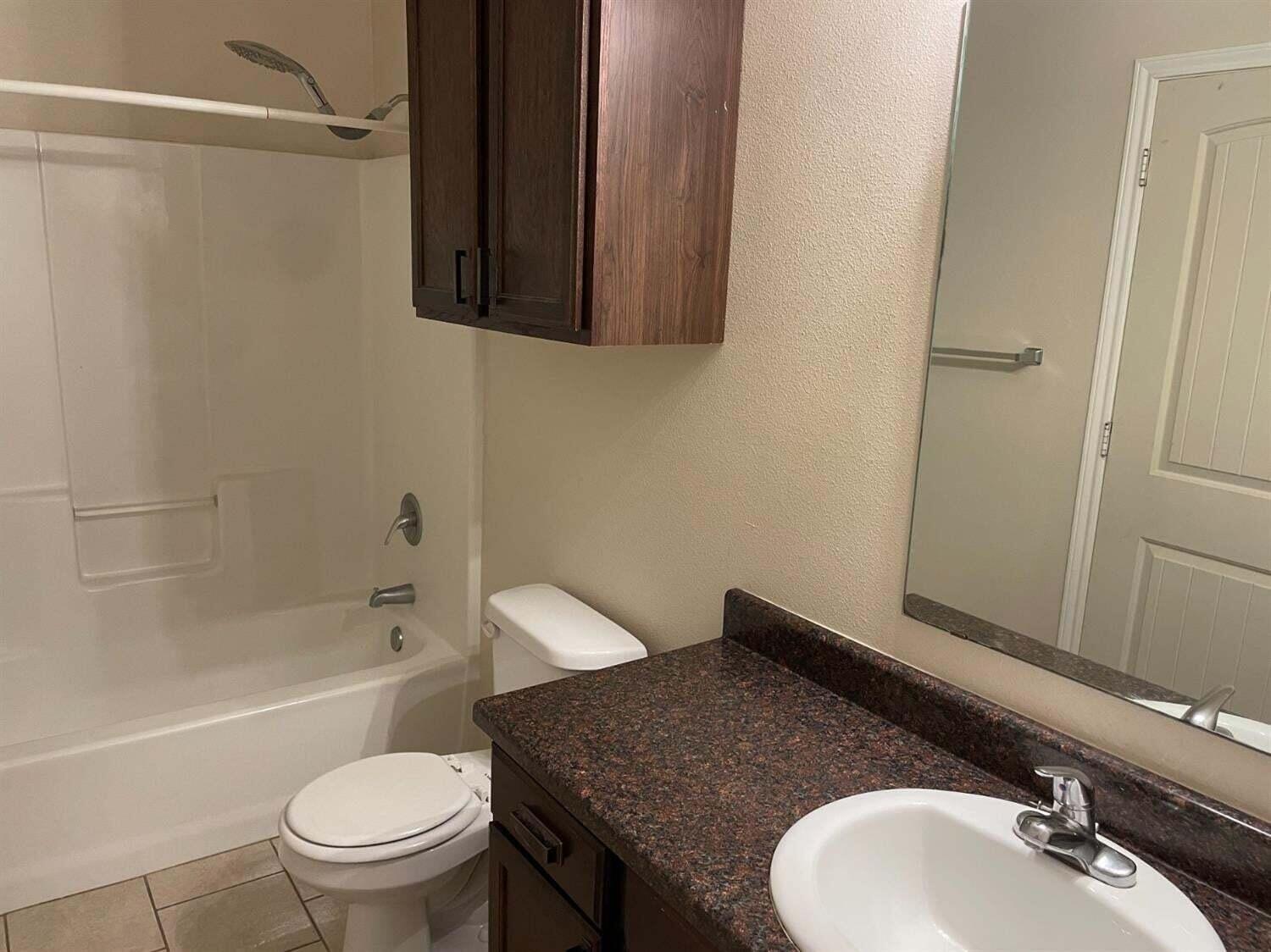 8912 Terrell Avenue Lubbock, TX 79423 - Photo 10 of 11 a bathroom with a granite countertop sink toilet and shower