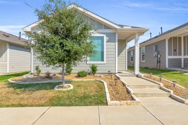 a view of house with backyard and sitting area