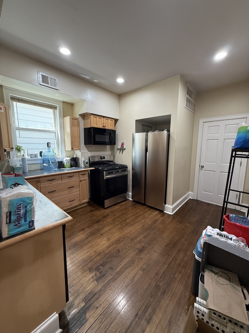 3252 West Crystal Street, Unit 2 Chicago, IL 60651 - Photo 6 of 13 a kitchen with stainless steel appliances granite countertop a refrigerator a sink dishwasher a stove and a refrigerator with wooden floor