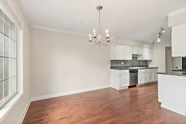 a large kitchen with granite countertop a sink cabinets and stainless steel appliances