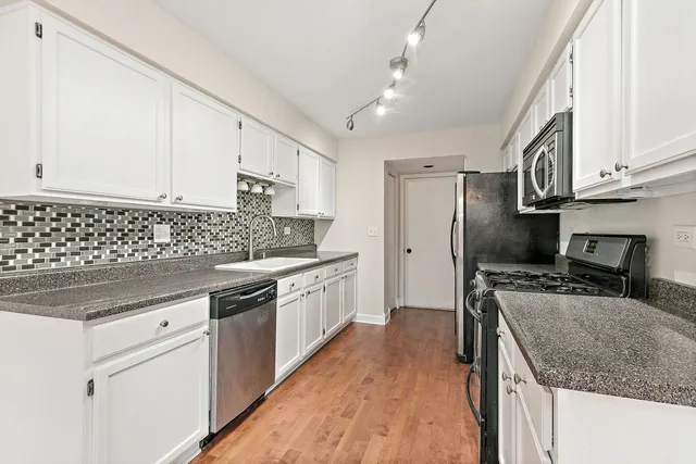 a kitchen with stainless steel appliances granite countertop a sink stove and refrigerator