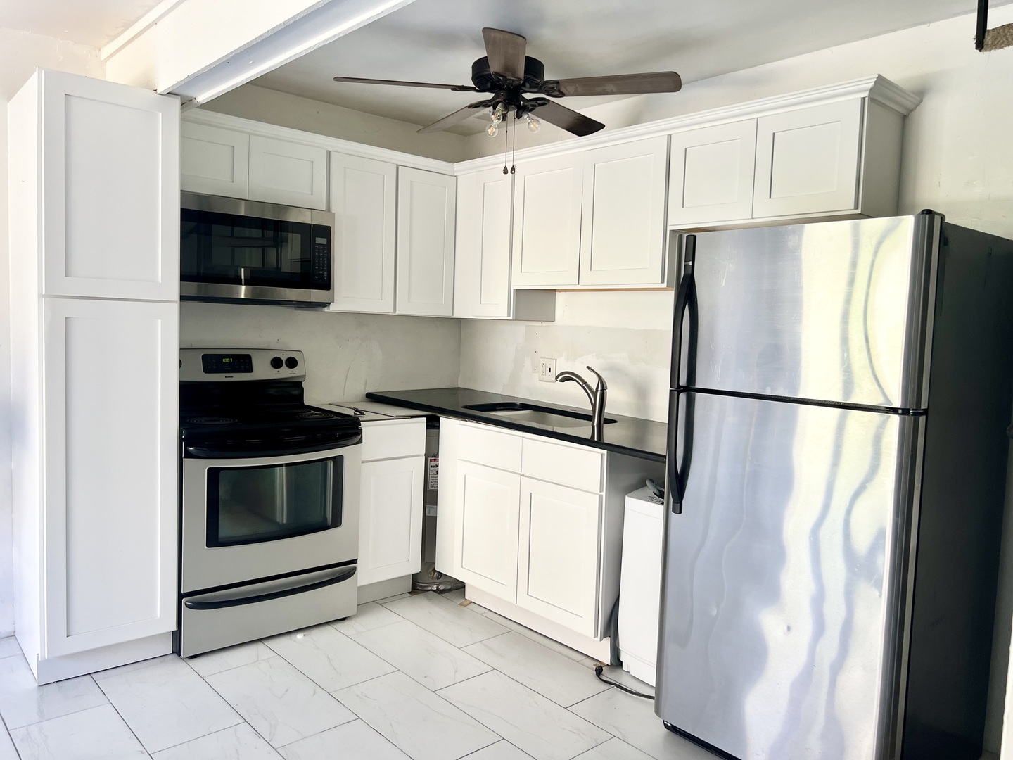 40 Bermuda Colony, Unit 7 Fox Lake, IL 60020 - Photo 3 of 20 a kitchen with stainless steel appliances granite countertop a refrigerator a microwave a sink and white cabinets