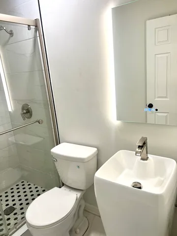a white toilet sitting next to a bathroom sink