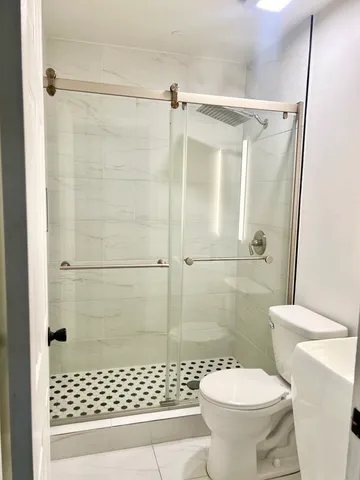 a bathroom with a toilet and a shower