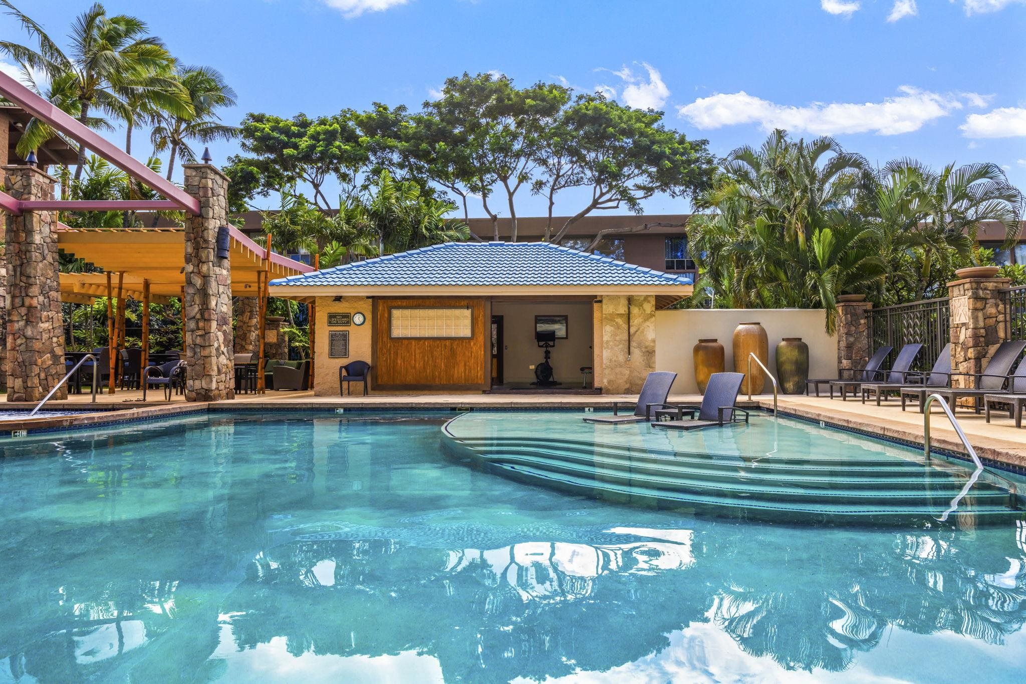 3708 Lower Honoapiilani Road, Unit E33 Lahaina, HI 96761 - Photo 2 of 36 a view of a swimming pool with lawn chairs under an umbrella