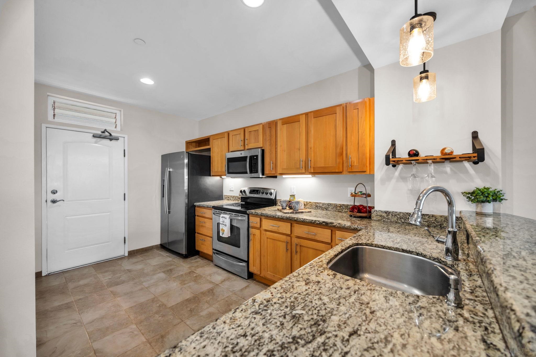 3708 Lower Honoapiilani Road, Unit E33 Lahaina, HI 96761 - Photo 7 of 36 a kitchen with stainless steel appliances granite countertop a sink stove and refrigerator