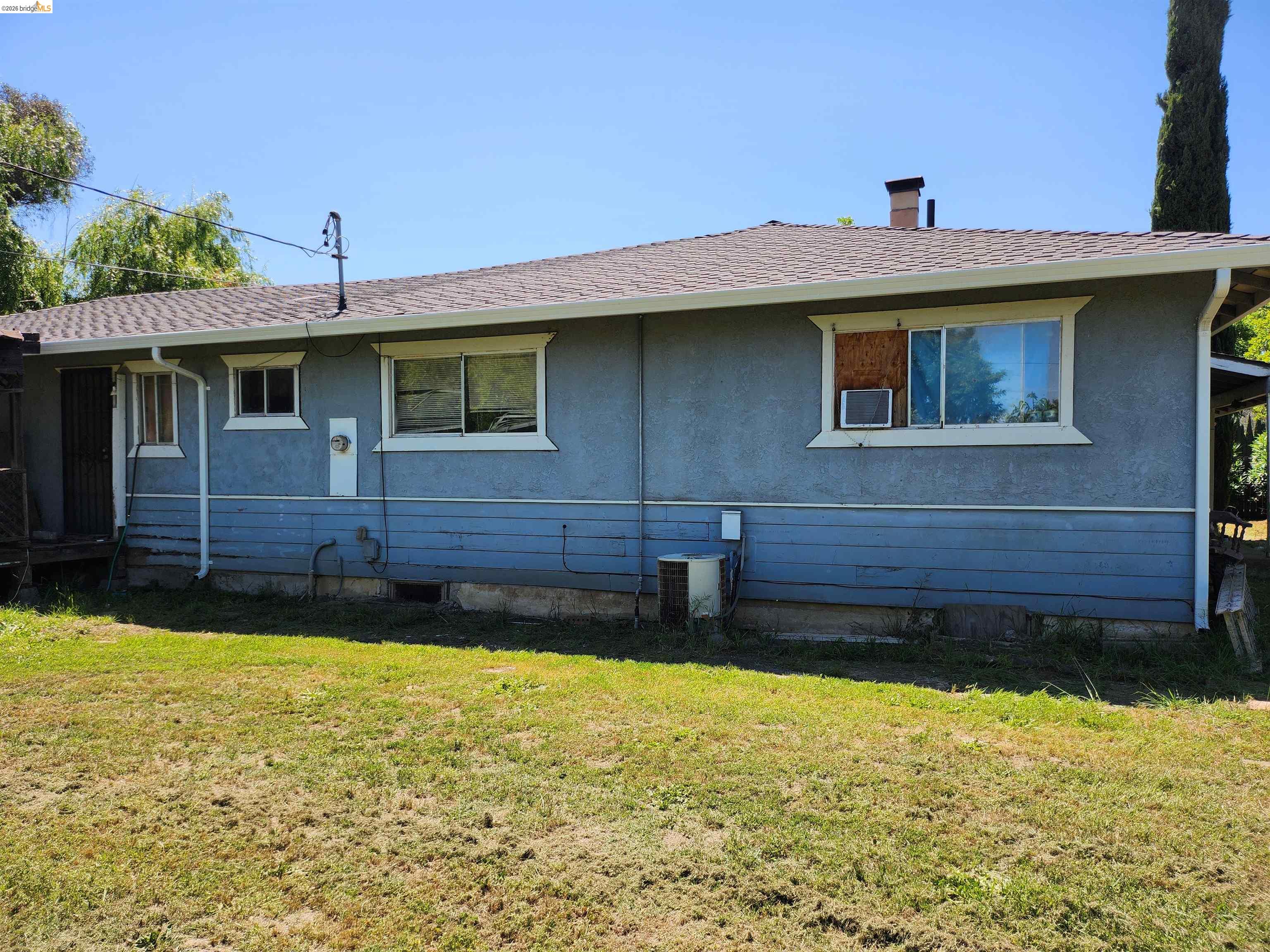 7750 Locke Road Vacaville, CA 95688 - Photo 22 of 23 Exterior features include a shingled roof, stucco siding, and a chimney stack