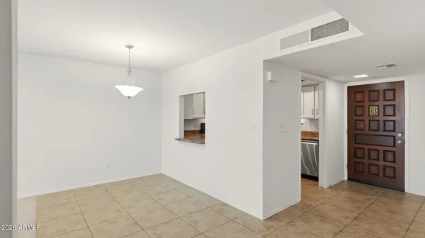 a view of an empty room with closet and a window