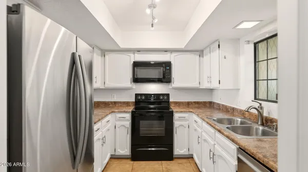 a kitchen with granite countertop a refrigerator stove and sink